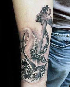 a man with a tattoo on his arm holding an anchor