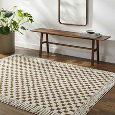 a white and brown rug sitting on top of a wooden floor next to a mirror