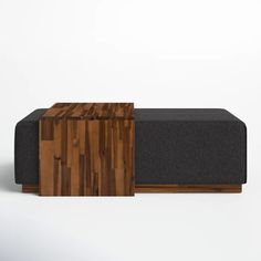 a wooden bench sitting on top of a white floor next to a black couch cushion