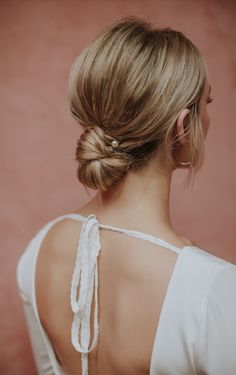 the back of a woman's head with braids in her hair, wearing a white top