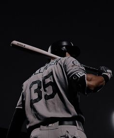 a baseball player holding a bat over his shoulder in the dark with a full moon behind him