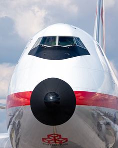 the tail end of an airplane that is white with red and black stripes on it