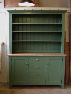 a green bookcase with drawers and cupboards