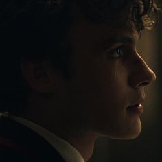 a close up of a person in a suit and tie looking off into the distance