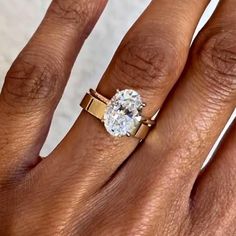 a woman's hand with a ring on it and a diamond in the middle