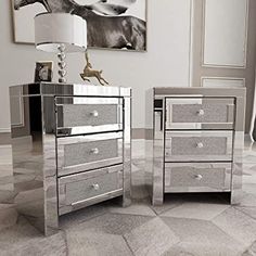 two mirrored nightstands with silver drawers on the floor in front of a large painting