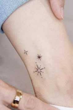 a woman's foot with two small stars tattoo on the left side of her ankle