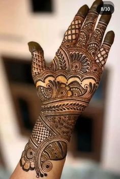 a hand with henna on it that is showing the intricate designs and patterns in different colors