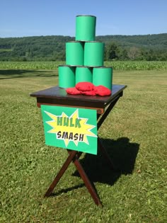 a table with green cups on it and a sign that says hulk smash in the middle