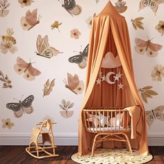 a baby crib in front of a wall with butterflies on it