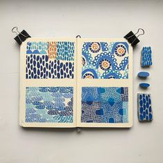 an open notebook with blue and orange designs on the pages, next to other items