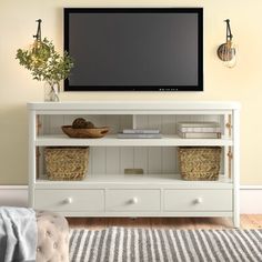 a flat screen tv mounted to the side of a white entertainment center in a living room