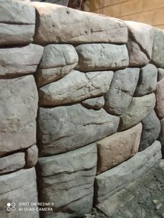 a stone wall made out of rocks in front of a building