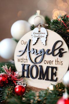 an ornament hanging from a christmas tree with ornaments around it and the words angels watch over this home