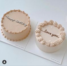 two birthday cakes sitting on top of a white table next to each other with the words happy birthday written on them