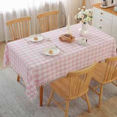 a dining room table set for four with plates and utensils on the table