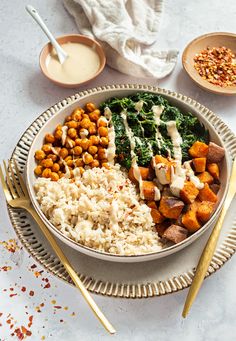 a bowl filled with rice, beans and spinach on top of a white table