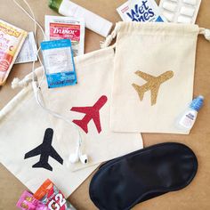 various travel items are laid out on the floor next to each other, including an air plane