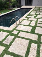 a pool with artificial grass around it and a ladder leading up to the water's edge