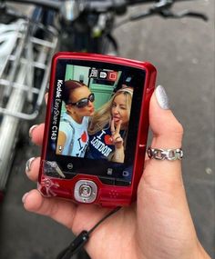 a woman holding up a red cell phone