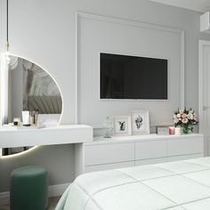 a bedroom with white furniture and a flat screen tv mounted on the wall above it