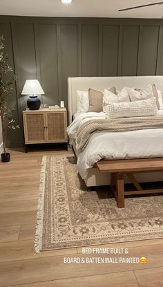 a large bed sitting on top of a hard wood floor next to a wooden table