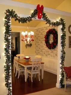 a mirror with christmas decorations on it in the middle of a living room and dining room