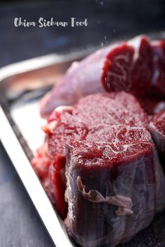 raw meat sitting on top of a metal tray