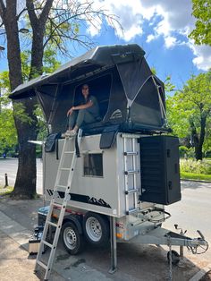 a man is sitting on top of a camper