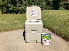 a toilet sitting on top of a sidewalk next to a box