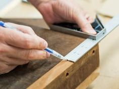 a person is using a ruler to measure something on a table with a cell phone