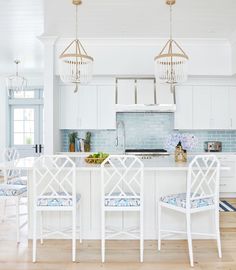 an instagramted photo of a kitchen with white furniture and blue accents on the walls