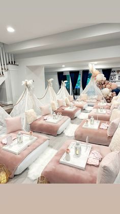 a room filled with lots of pink couches covered in white blankets and pillows on top of each other