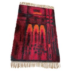 a red and black rug with fringes on it