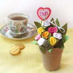 a small potted plant sitting on top of a table next to a cup of coffee