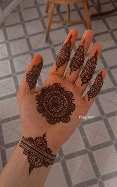 a person's hand with henna tattoos on it