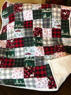 a quilted christmas blanket sitting on top of a wooden floor