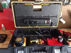 an open tool box with tools inside on a workbench in a workshop area