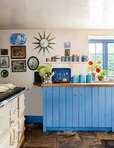 a blue and white kitchen with lots of pictures on the wall behind the counter top