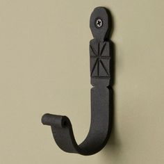 an iron hook is attached to the wall with a decorative design on it's side