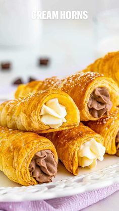 several pastries on a white plate with chocolate and cream