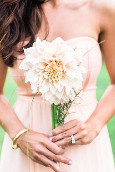 a woman in a pink dress holding a white flower