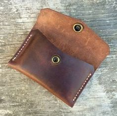 a brown leather wallet sitting on top of a wooden table