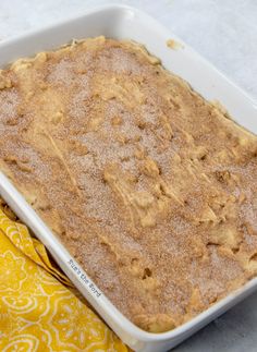 a pan filled with food sitting on top of a yellow cloth next to a napkin