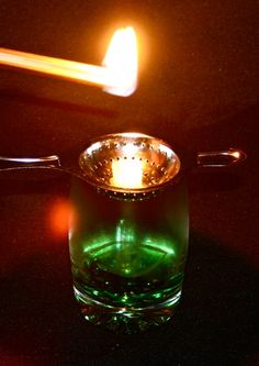 a lit matchstick sitting on top of a glass cup