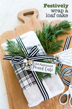 a wooden cutting board topped with wrapping paper and twine tied to it's sides