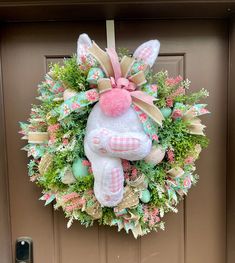 a wreath with an easter bunny hanging on the front door to give as a decoration