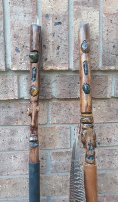 two wooden carvings are attached to the side of a brick wall and one is holding a feather