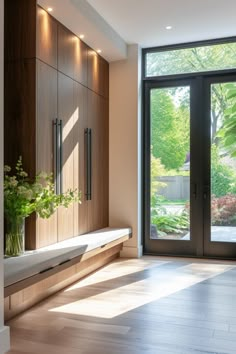 an empty room with large sliding glass doors and wood flooring, along with a planter filled with flowers