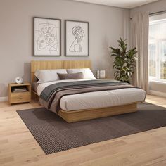 a bedroom with hardwood floors and two pictures on the wall above the bed, in front of a large window